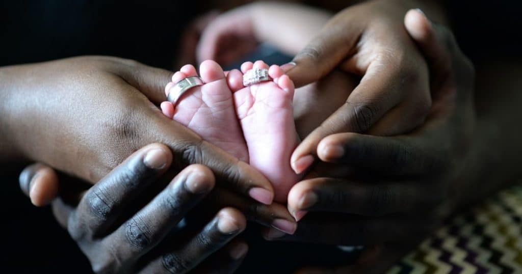Joyful family holding baby's feet